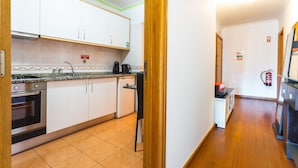 A kitchen with white cabinets, a black countertop, and a wooden floor. - Sweet Home Reis Magos by Atlantic Holiday (Caniço)