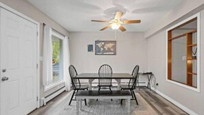 A dining room with a table, chairs, a ceiling fan, and a rug. - Midnight Sun Viewpoint Aurora (Fairbanks)