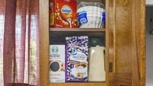 A kitchen with a coffee maker, a cabinet with food items, and a stove. - Alaska Rafiki - Unit 3 (Fairbanks)