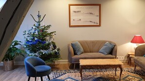 Una sala de estar acogedora con un árbol de Navidad, un sofá, una mesita de centro y una lámpara.