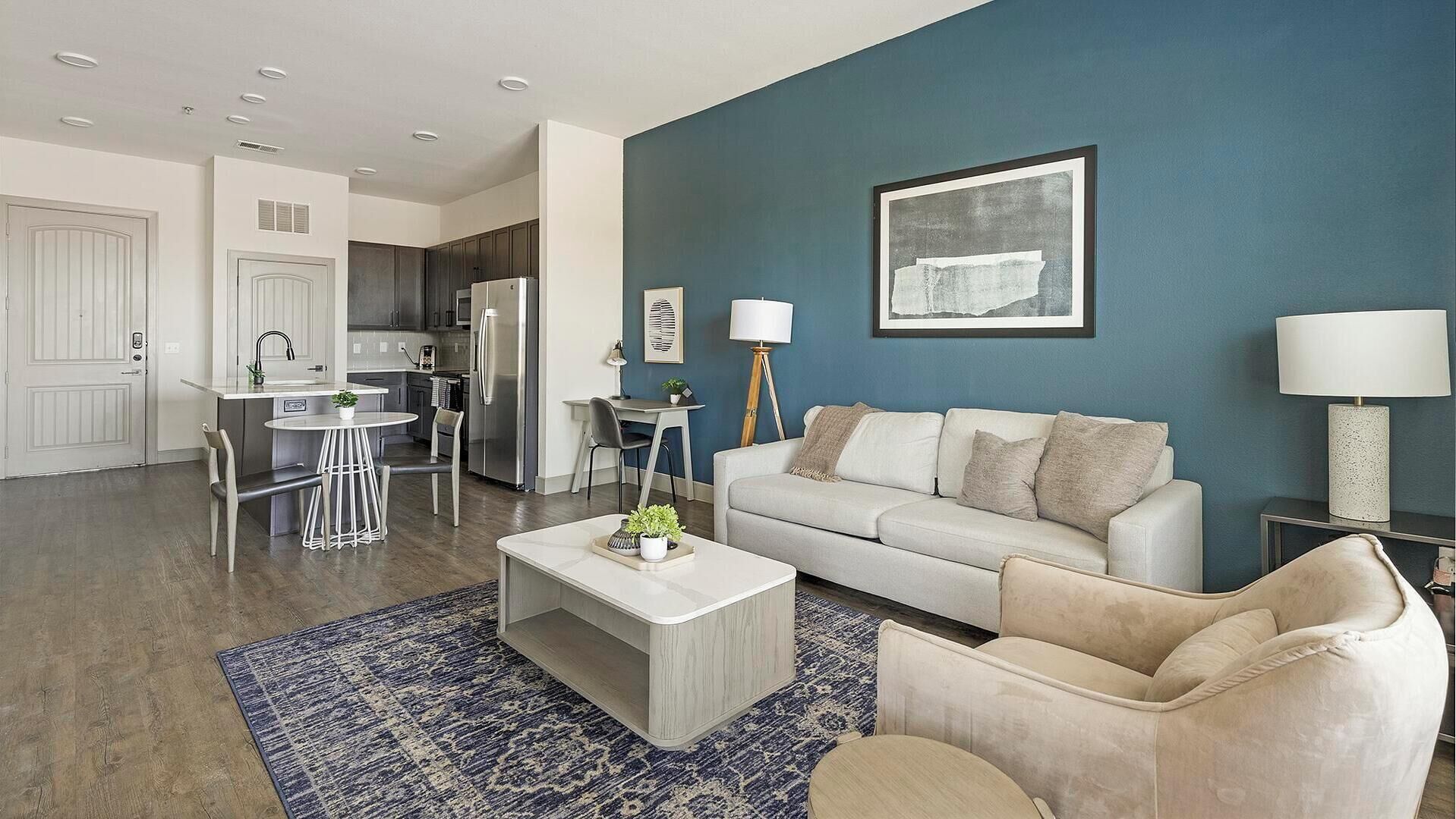 Un salon moderne avec un canapé blanc, une table basse et un tapis bleu.