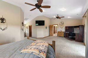 A spacious bedroom with a large bed, two ceiling fans, a TV, and a desk area with a chair. - Best Views, Hot Tub, Game Room! 10 minutes to Zion (Orderville)