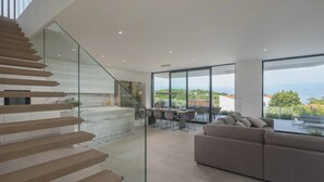 Ein modernes Interieur mit Treppe, Essbereich und einer Couch.