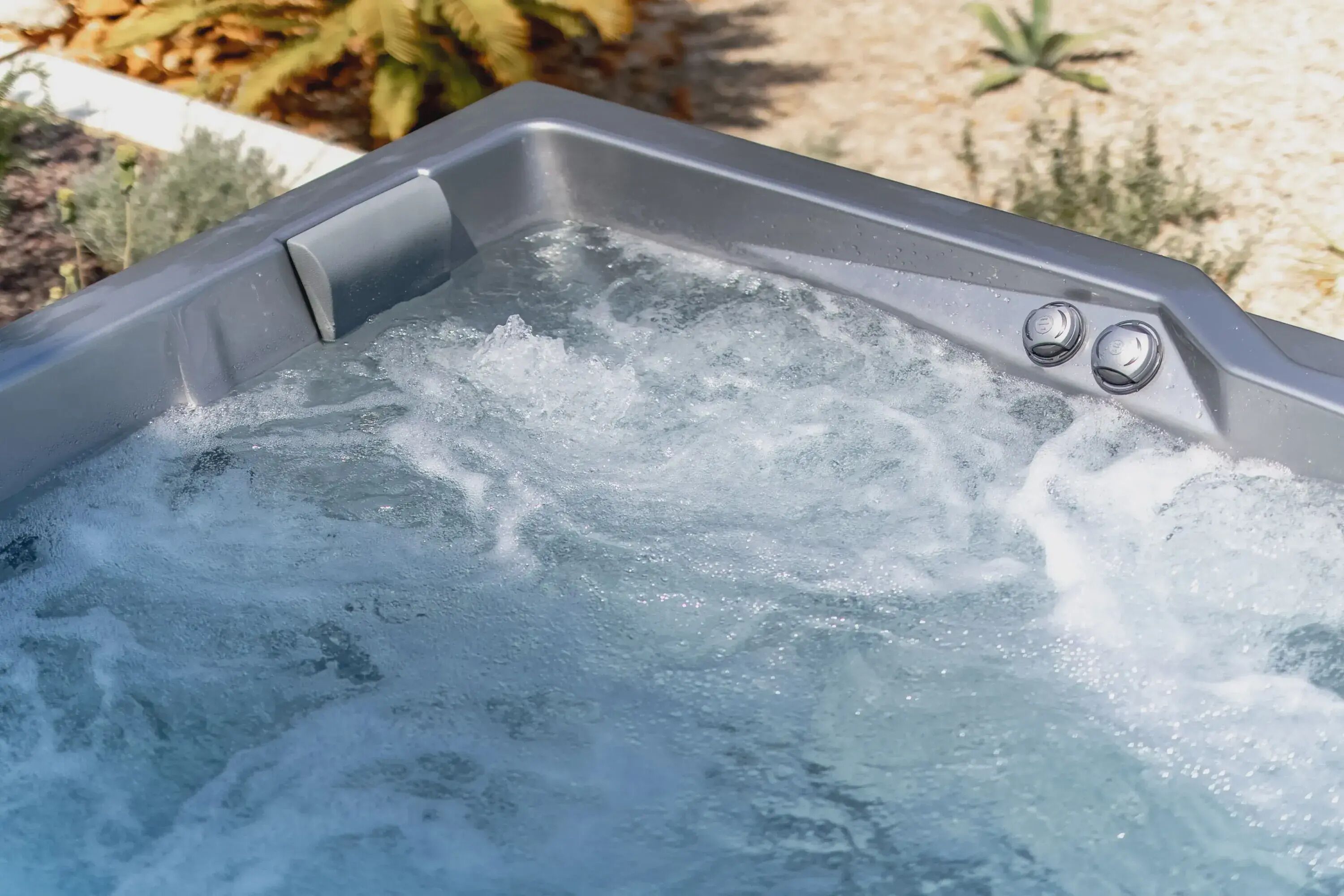 Een bubbelbad met opwellend water, omringd door planten.
