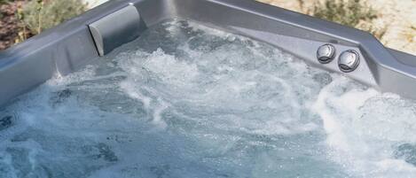 Een bubbelbad met opwellend water, omringd door planten.