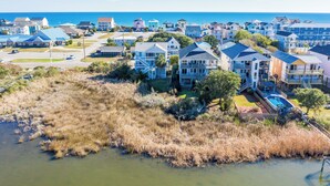 A coastal residential area with houses, a swimming pool, and a view of the ocean. - 421 N. New River Units A and B (surf city)