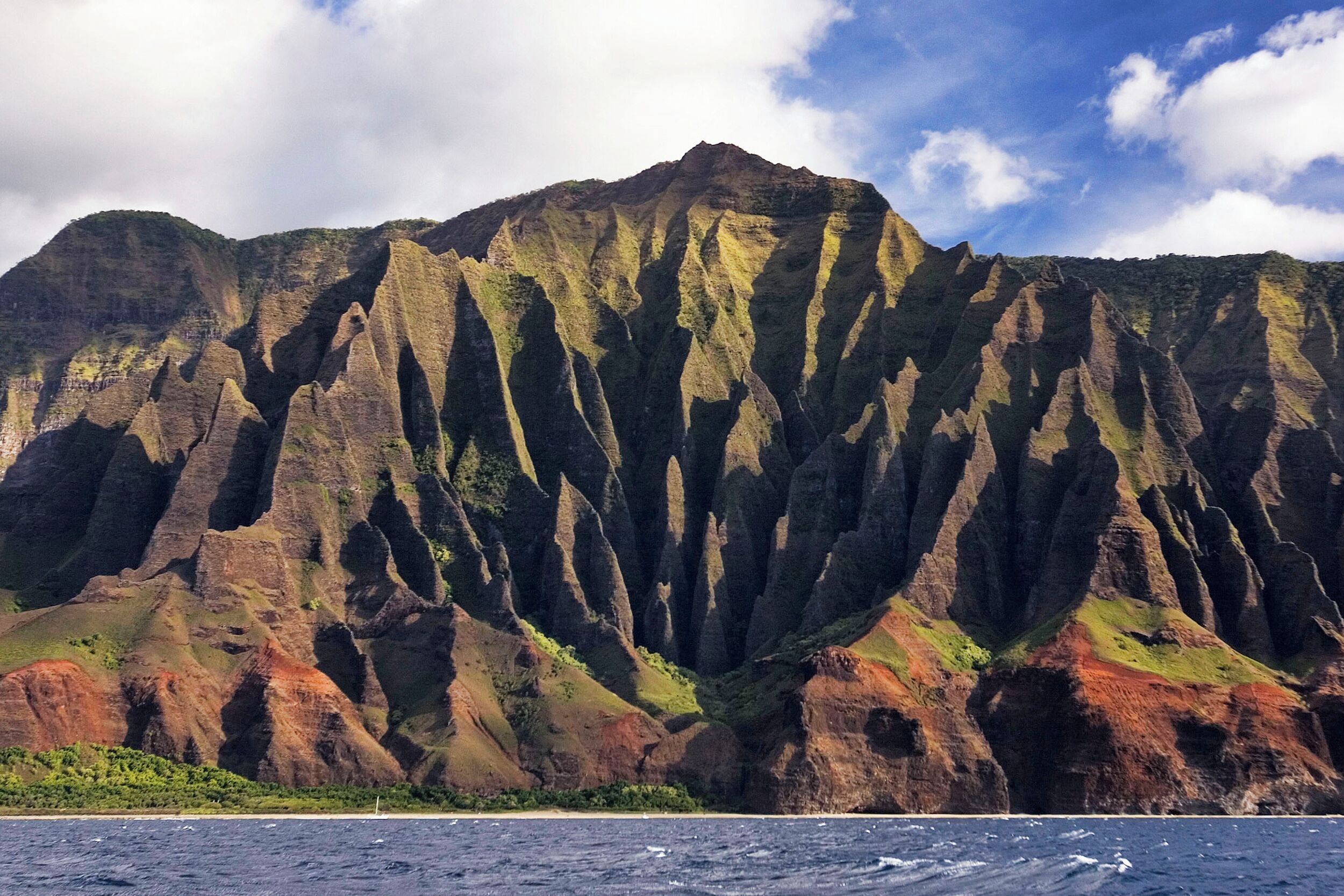 A mountain with steep cliffs and a clear sky.
