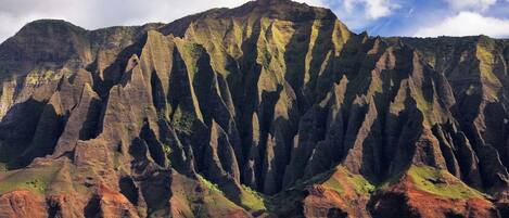 A mountain with steep cliffs and a clear sky.