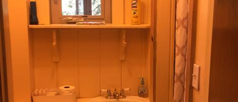 A compact bathroom with a sink, toilet, and window.