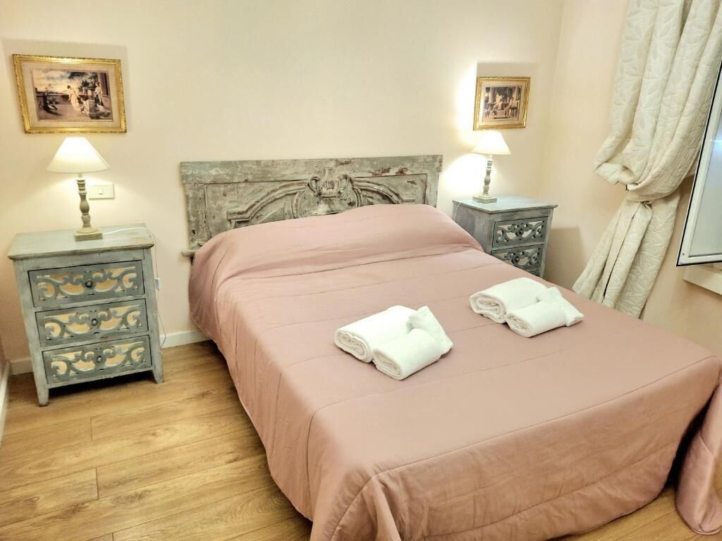 A bedroom with a bed, two nightstands, and a headboard.