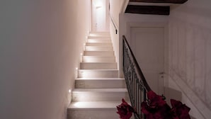 A staircase with white steps and a metal railing, leading to a door at the top.