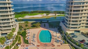 A resort with a large pool, multiple balconies, and a view of the ocean. - 2/2 Bay Front Condo, Pool, Private Beach Access (Longboat Key)