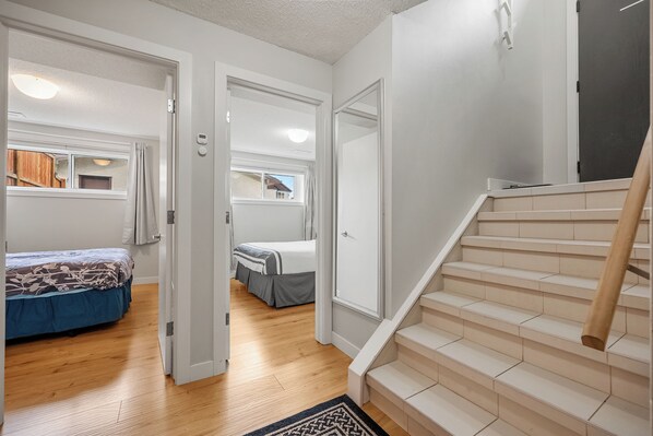 A staircase leading to a bedroom with a bed and a window. - Cozy and comfy two-unit home in the Calgary core (Calgary)