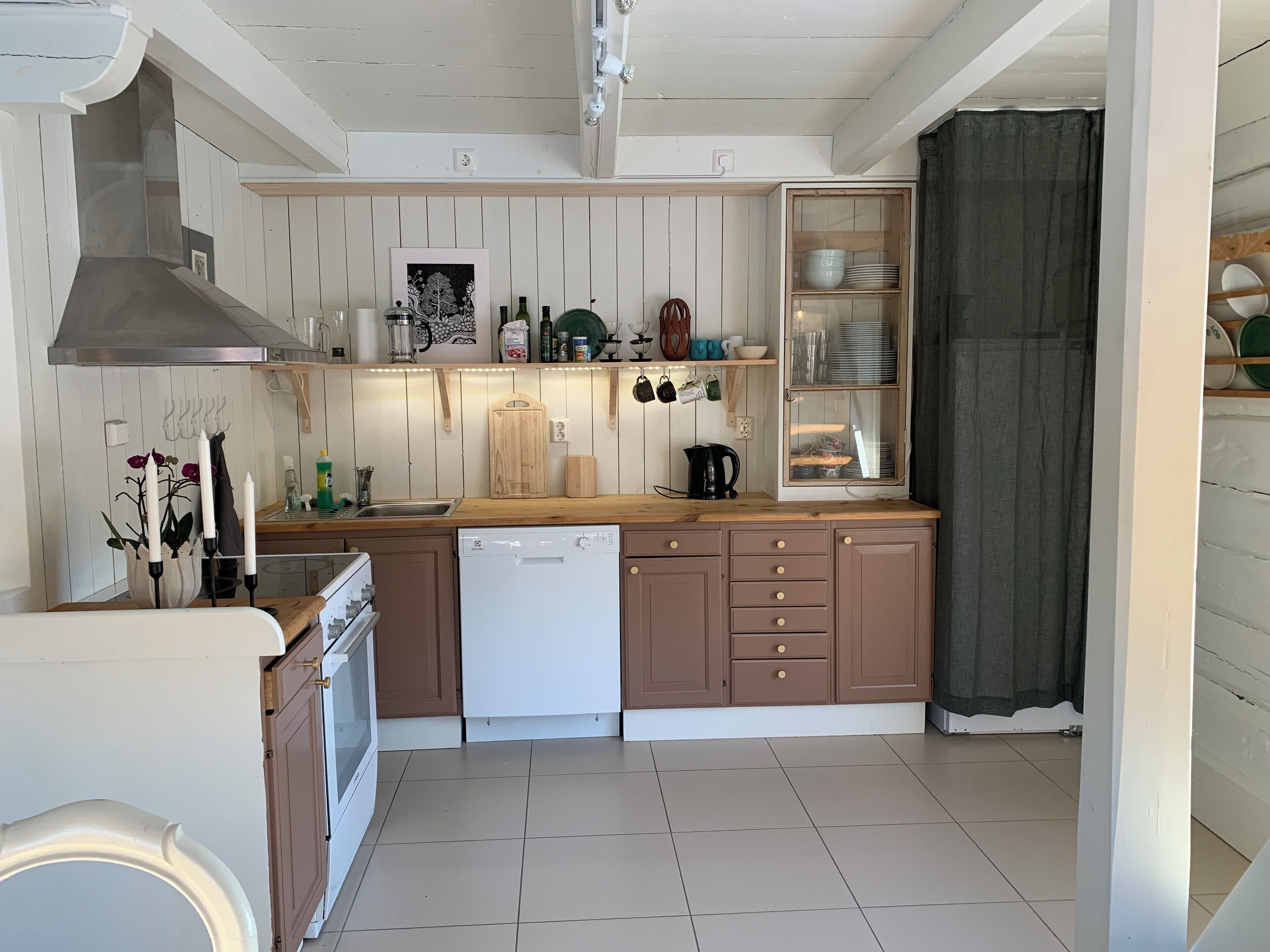 Keittiössä on puukehikoiset kaapit, astianpesukone, liesi ja kahvinkeitin.