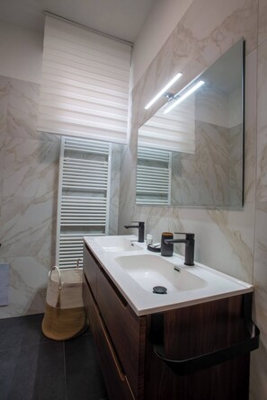 A modern bathroom with two sinks, a large mirror, and a towel rack. - HouSmart Lorenzo Costa 17 (Bologna)