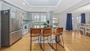Een moderne keuken met een centraal eiland, roestvrijstalen apparatuur en een dakraam.