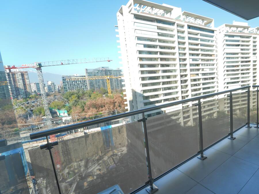 A high-rise building with multiple balconies and a construction crane in the background.