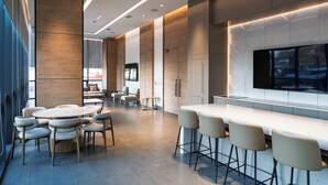 A modern interior with a round dining table, bar area, and seating. - Spot Suites (Santiago)