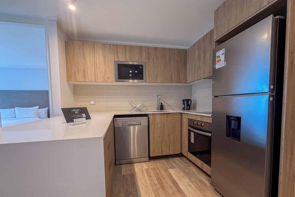 A modern kitchen with wooden cabinets, stainless steel appliances, and a built-in dishwasher.