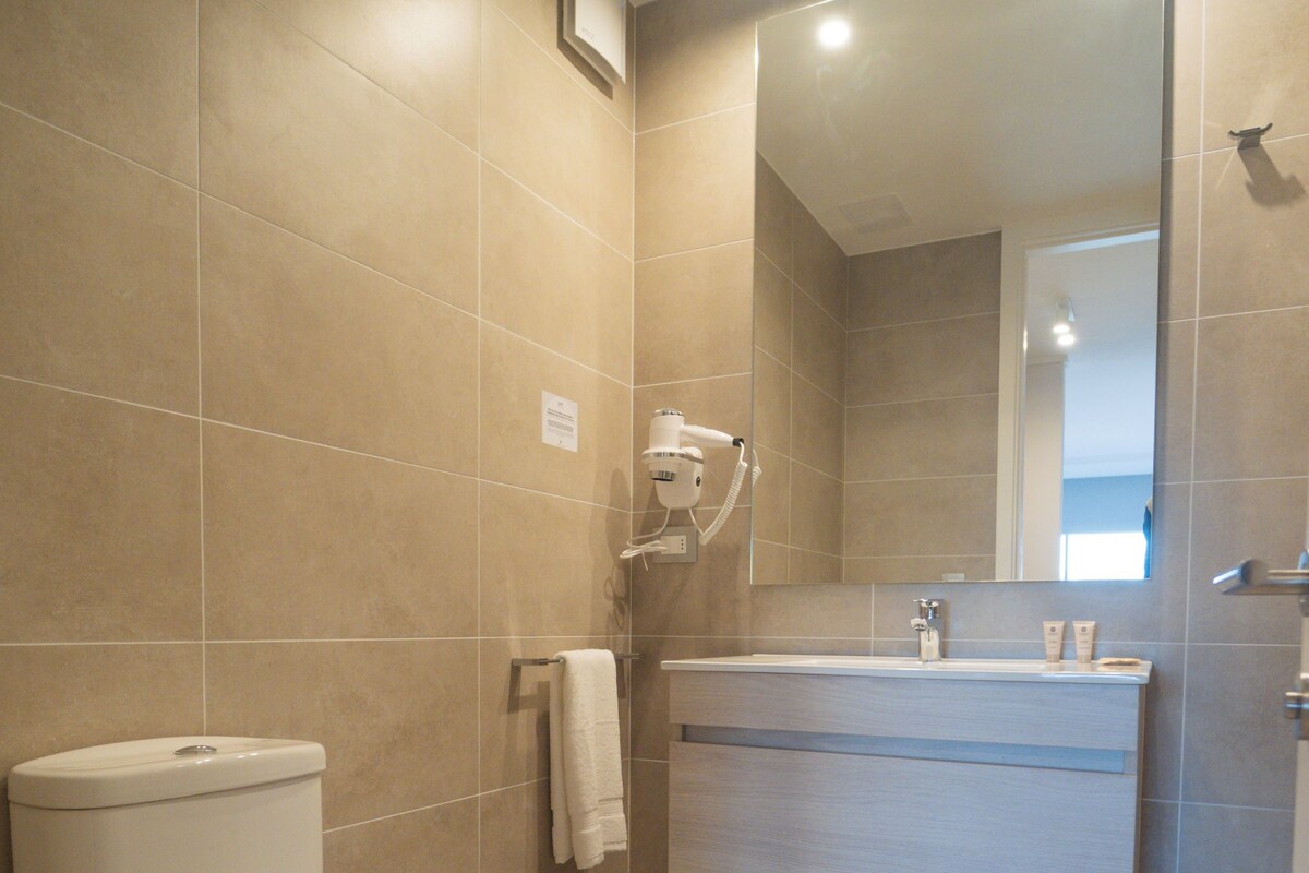A modern bathroom with a toilet, sink, and shower area.