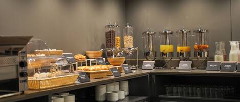 A breakfast buffet with various food items and beverages.