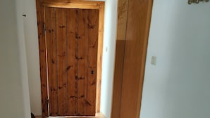 Un pasillo con suelo de madera y dos puertas de madera.
