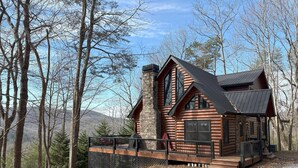 A log cabin with a stone chimney, large windows, and a covered porch. - BLUE RIDGE SPLENDOR - 3 BR, 3 BA amazing cabin, with incredible mountain views! (Cherry Log)