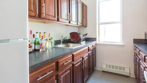 A kitchen with wooden cabinets, a sink, and a window.