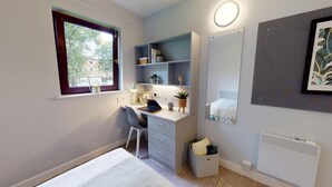 Une chambre à coucher moderne avec un bureau, une chaise et un lit.