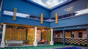 Un edificio moderno con un suelo estampado en cuadros, una piscina y un cartel que dice "DE PALATIAL RESORT".