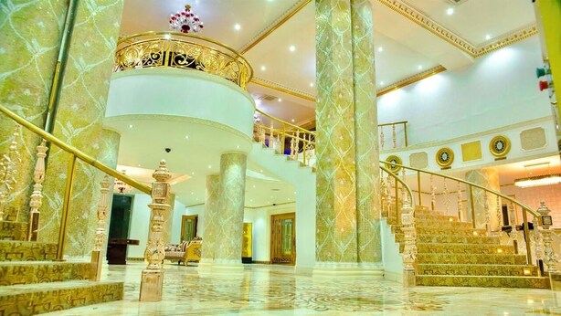 A grand lobby with marble floors, a central staircase, and ornate railings. - Golden Vista Hotels (Owerri)