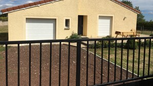 Un bâtiment d’un seul étage, à la façade de couleur beige, doté de deux portes de garage et d’une petite fenêtre.