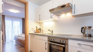 Una cucina moderna con elettrodomestici in acciaio inossidabile, forno integrato e macchina per il caffè.