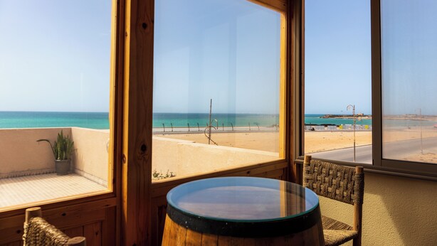 A room with a large window overlooking a beach. - The Ocean Villa  (Dakhla)
