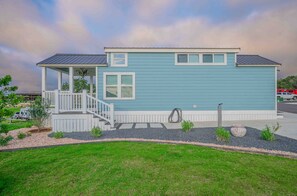 Une maison de plain-pied dotée d’un porche et d’une petite terrasse, entourée d’un jardin aménagé.