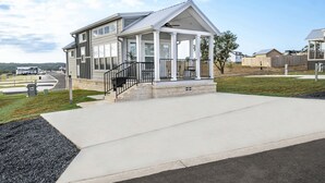 A modern house with a covered porch, a staircase, and a driveway. - Bella Vista - 052 (Fredericksburg)