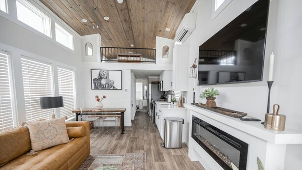 A spacious living area with a high ceiling, a fireplace, a dining area, and a kitchen. - Bella Vista - 052 (Fredericksburg)