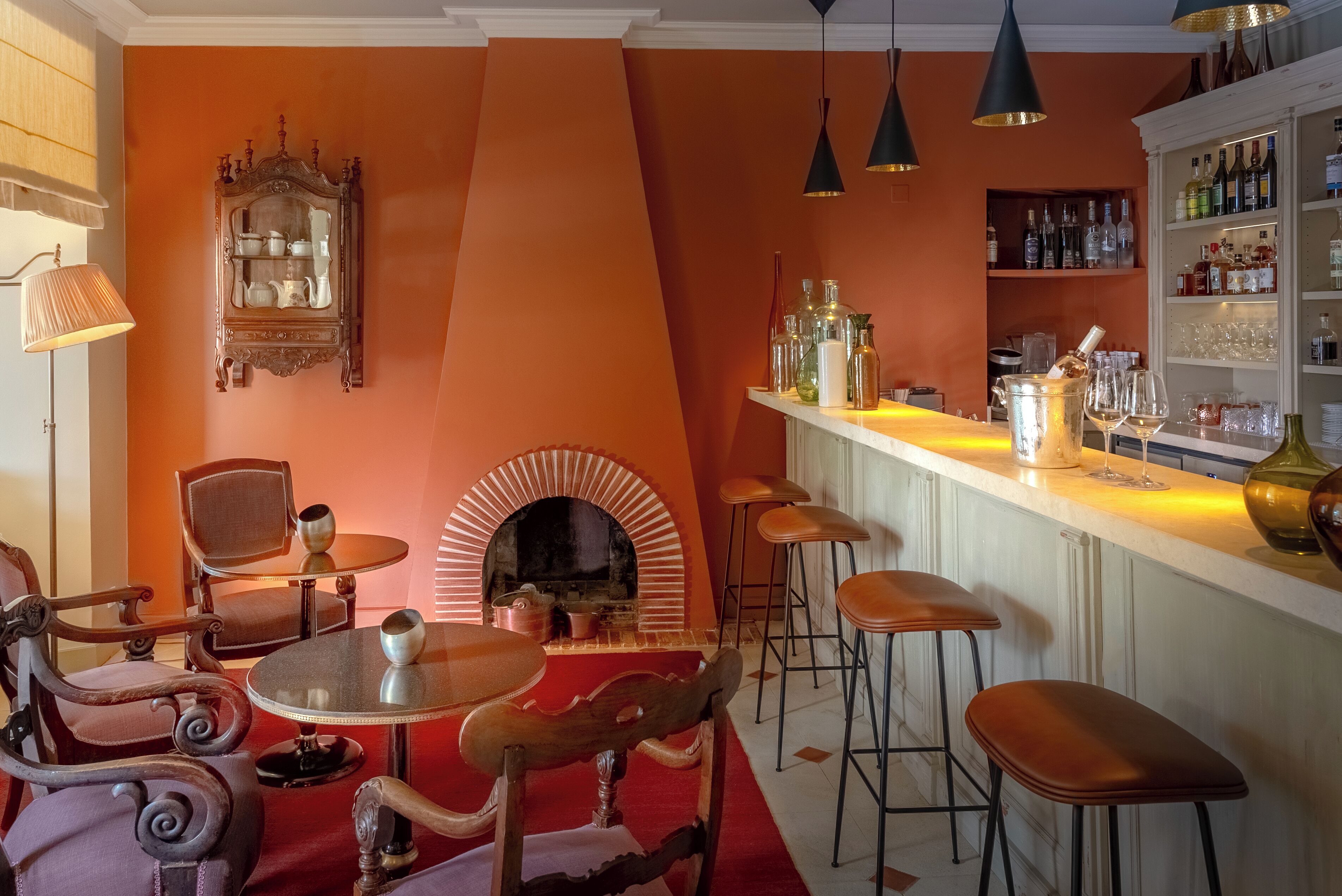 Un espace bar doté d’une cheminée, de tabourets de bar et d’un présentoir pour les bouteilles de vin.