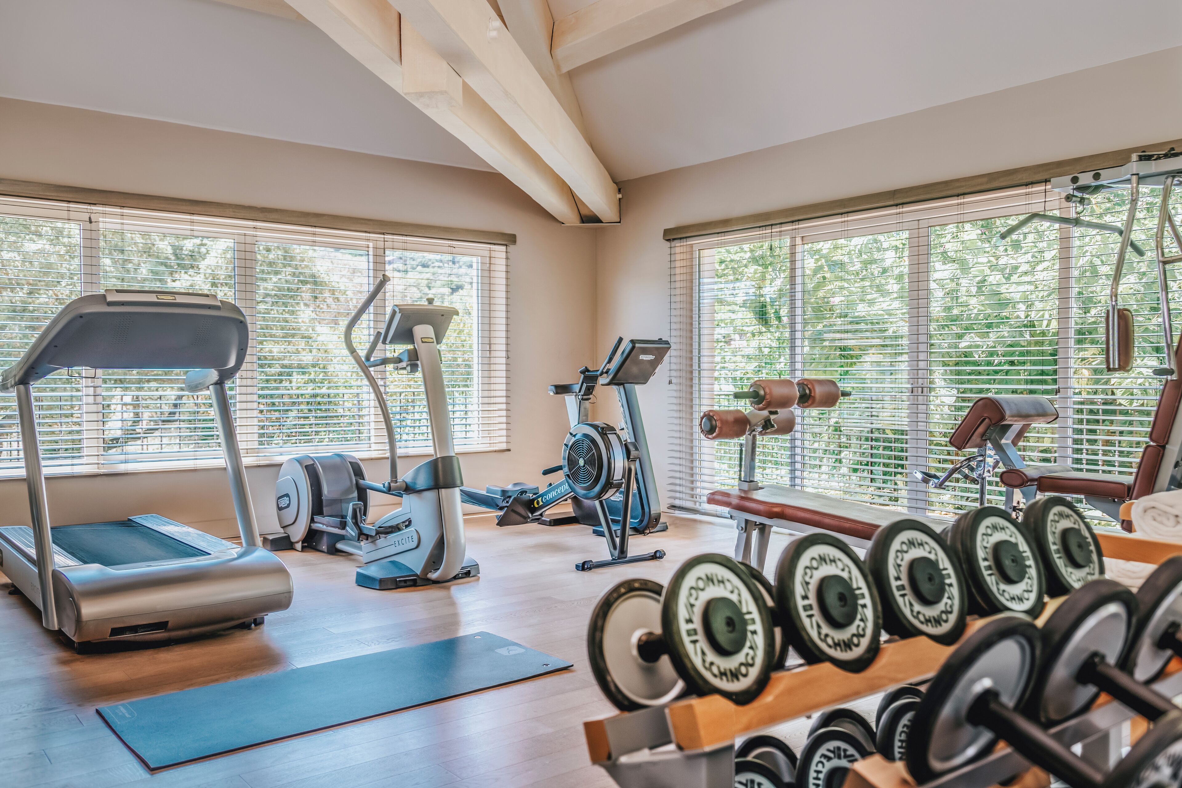 Une salle de sport équipée de tapis de course, de vélos elliptiques et de poids libres.