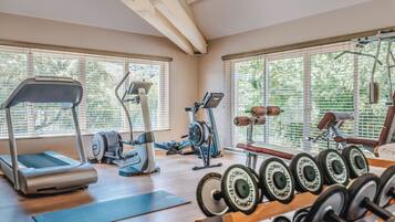 Une salle de sport équipée de tapis de course, de vélos elliptiques et de poids libres.