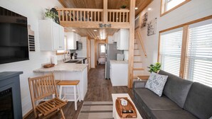 Une cuisine moderne avec des armoires blanches, un plafond en bois et un îlot central.