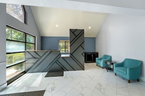 A modern interior with a reception desk, seating area, and large windows. - Deluxe Studio at Extended Stay Cary 1 (Cary)