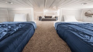 Une chambre avec deux lits, un canapé et un sol recouvert d’une moquette.