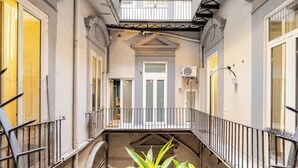 A narrow corridor with a balcony, a door, and an air conditioning unit. - Green Chiaia three (Napoli)