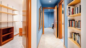 A hallway with wooden shelves, a mirror, and a door leading to another room. - Green Chiaia three (Napoli)