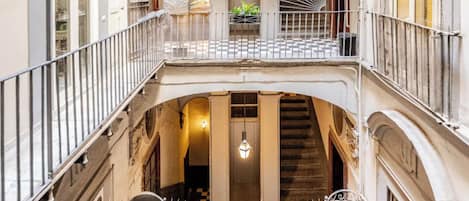 Interior com vários níveis, varandas, escadarias e piso xadrez.