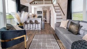Ein modernes Interieur mit Wohnbereich, Küche und Treppe.