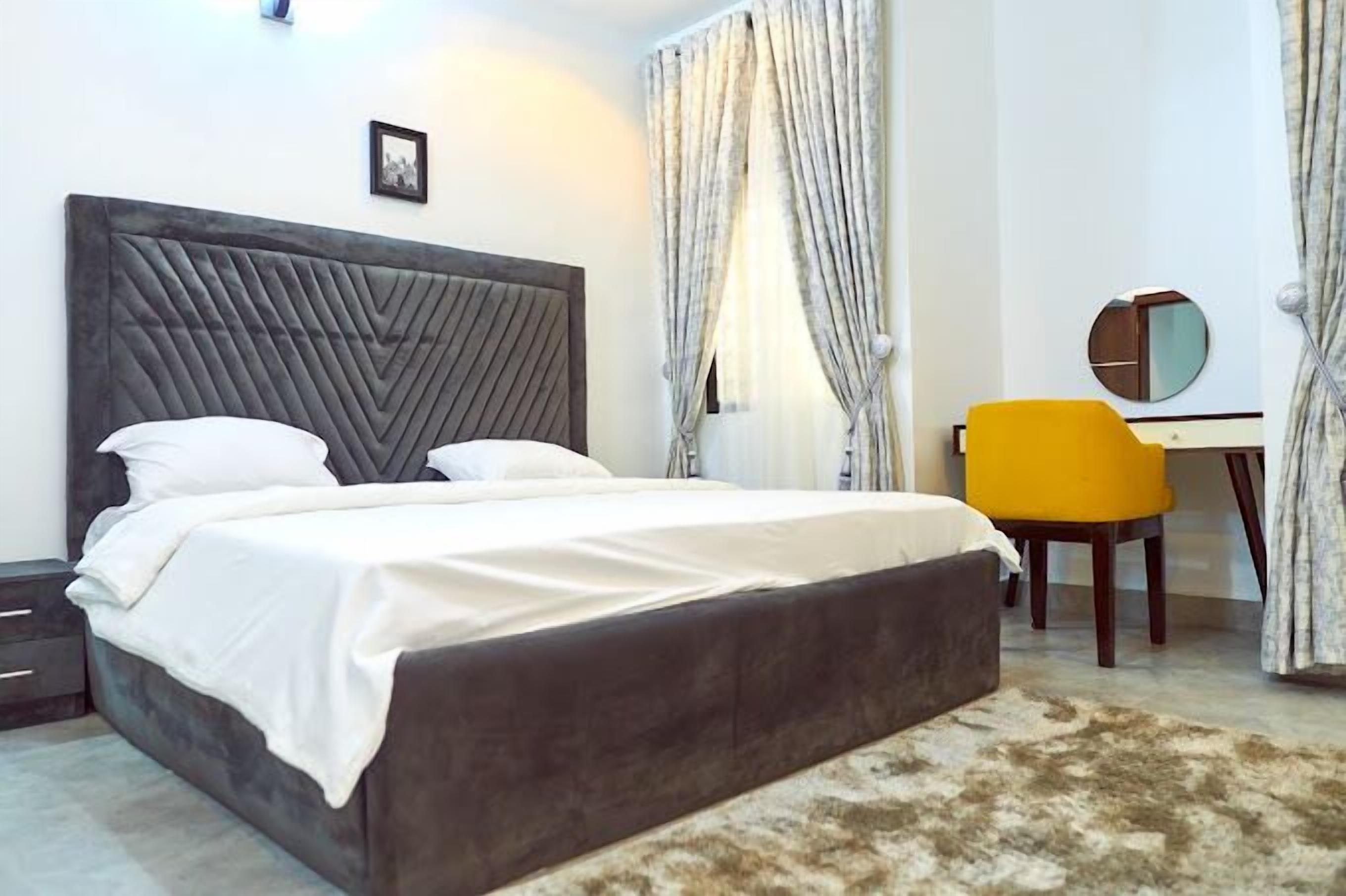 Une chambre à coucher moderne avec un grand lit, un bureau et une chaise.