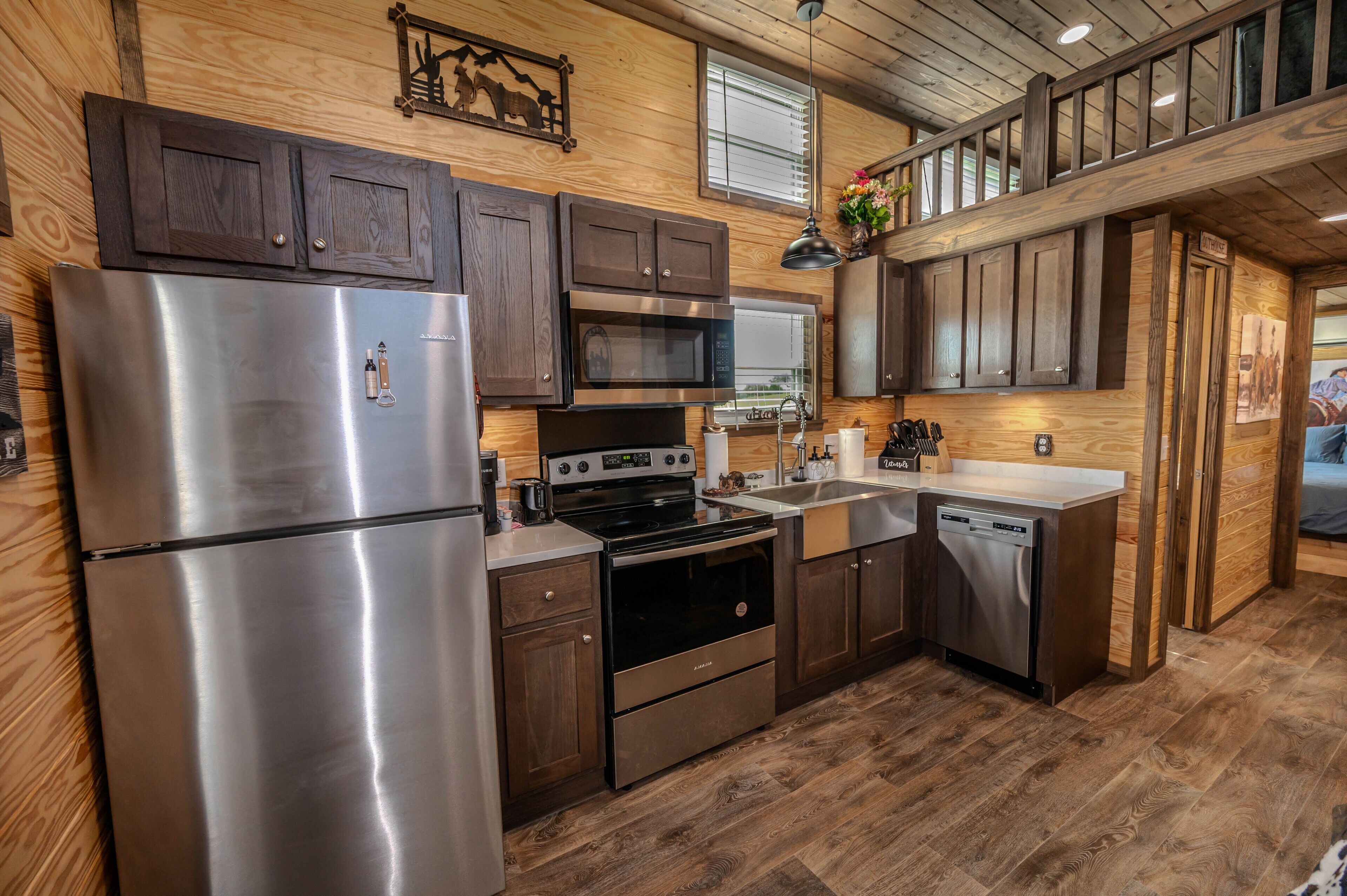 A modern kitchen with stainless steel appliances, wooden cabinets, and a built-in oven.