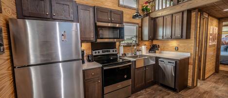 A modern kitchen with stainless steel appliances, wooden cabinets, and a built-in oven.